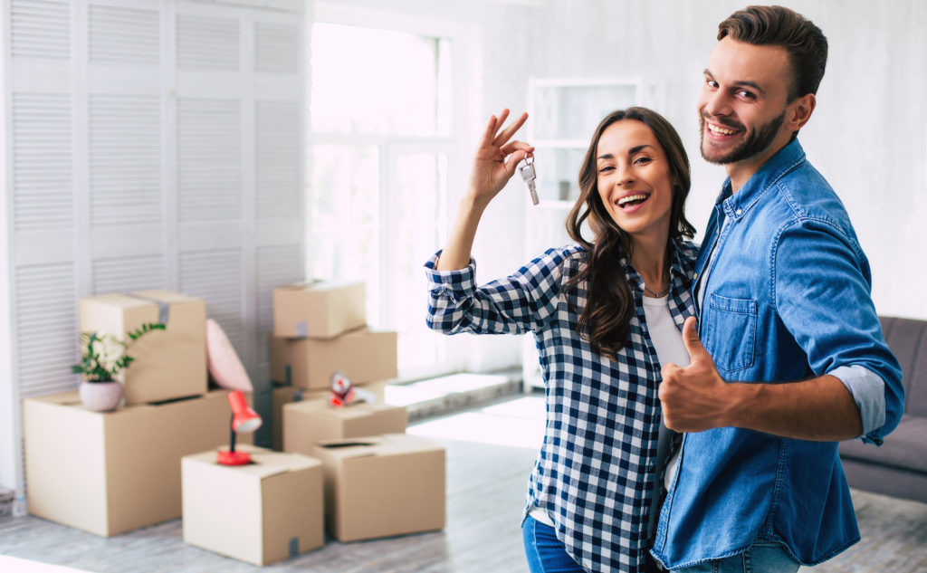 Réussir son emménagement - un couple est heureux d'emménager dans leur nouvelle maison neuve et s'apprêtent à déballer les cartons